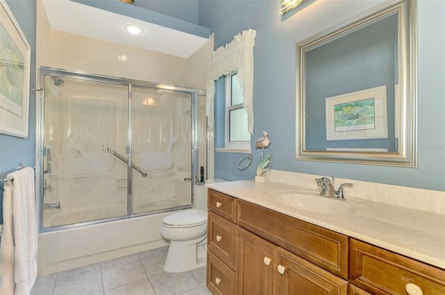 bathroom featuring shower / bath combination with glass door, vanity, toilet, and tile patterned floors