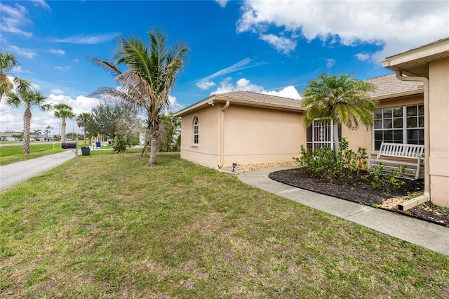 view of side of property with a lawn