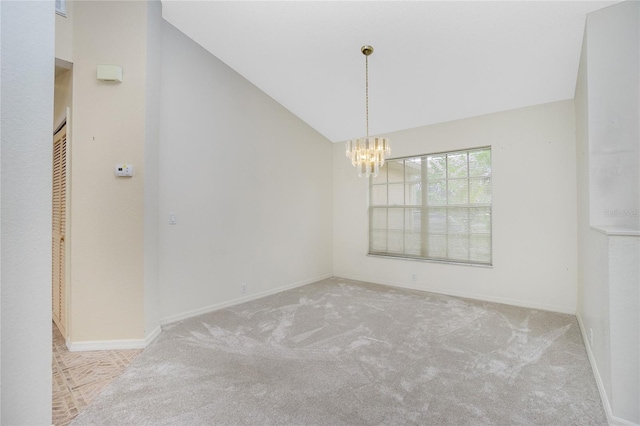 carpeted spare room featuring an inviting chandelier and lofted ceiling