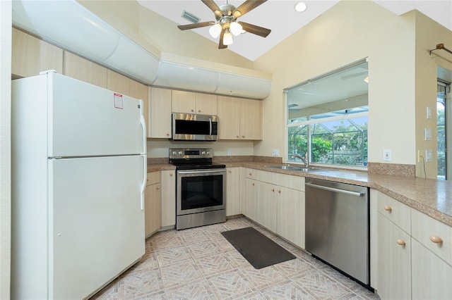 kitchen featuring appliances with stainless steel finishes, ceiling fan, sink, and vaulted ceiling