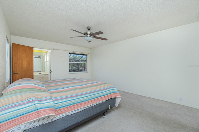 carpeted bedroom with ceiling fan, a textured ceiling, and ensuite bathroom