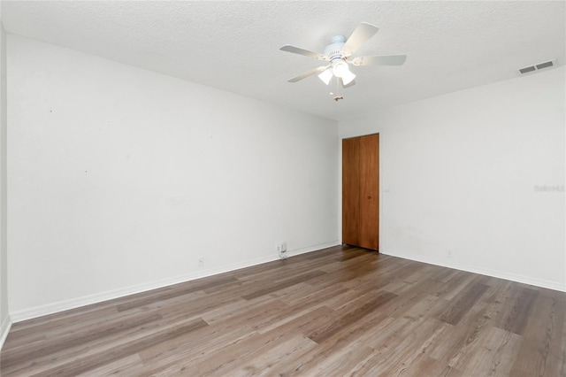 spare room with a textured ceiling, hardwood / wood-style flooring, and ceiling fan