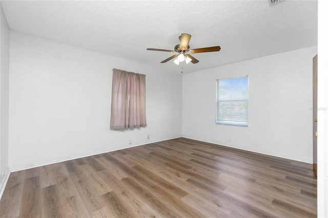 empty room featuring a textured ceiling, ceiling fan, and wood-type flooring