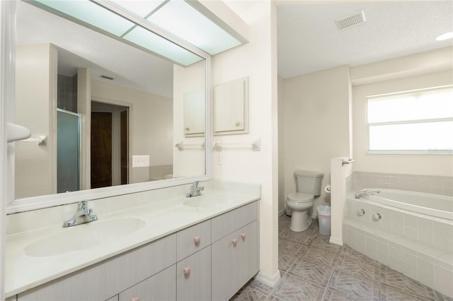 bathroom featuring a textured ceiling, vanity, toilet, and a relaxing tiled tub