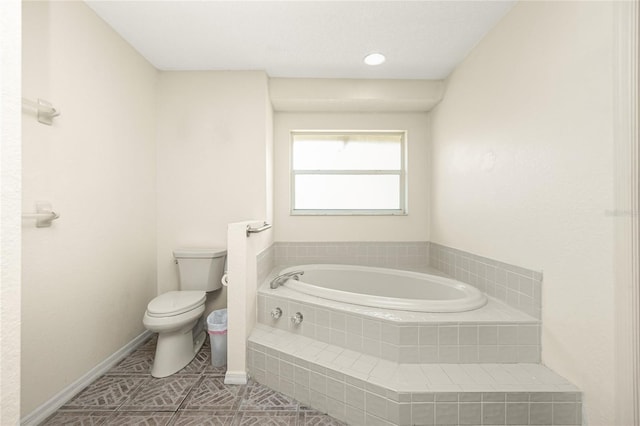 bathroom with tiled bath, tile patterned flooring, and toilet