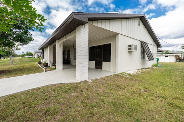 view of property exterior with an AC wall unit, a lawn, and a carport