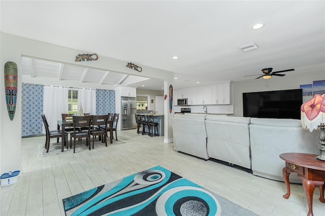 living room with beam ceiling, ceiling fan, and light hardwood / wood-style floors