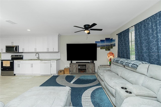 living room featuring ceiling fan and sink