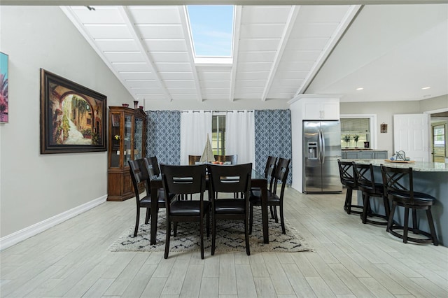 dining room featuring light hardwood / wood-style flooring and lofted ceiling with beams