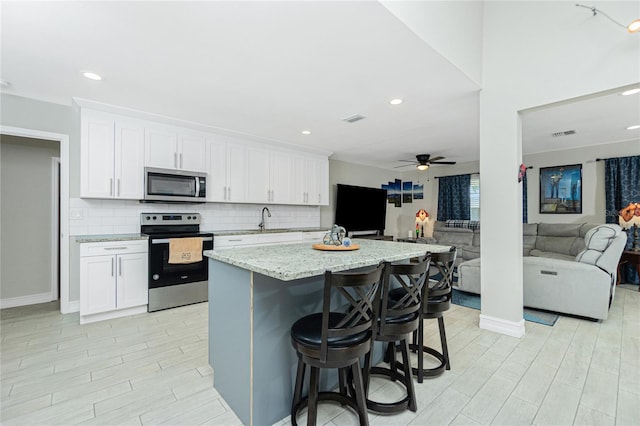 kitchen with white cabinetry, a kitchen island, and stainless steel appliances