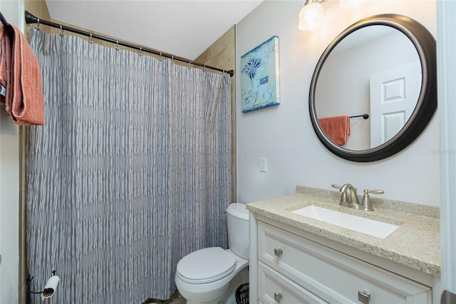 bathroom with toilet, vanity, and walk in shower