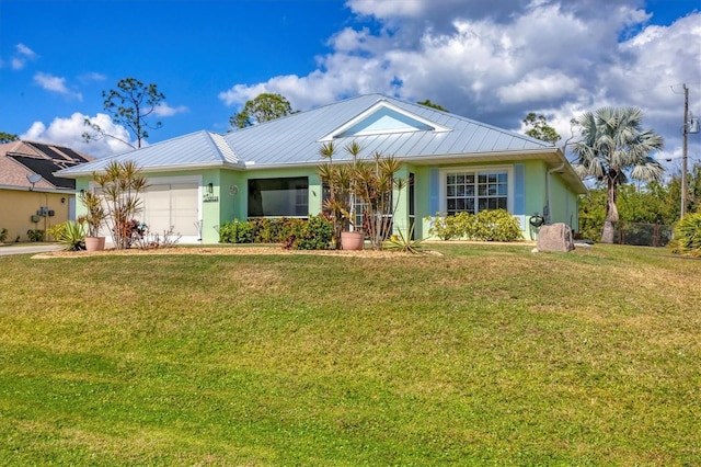 ranch-style house with a garage, stucco siding, metal roof, and a front yard