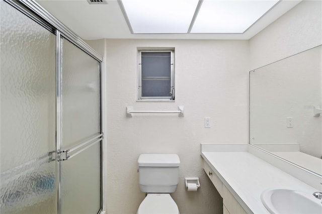 bathroom with walk in shower, vanity, and toilet