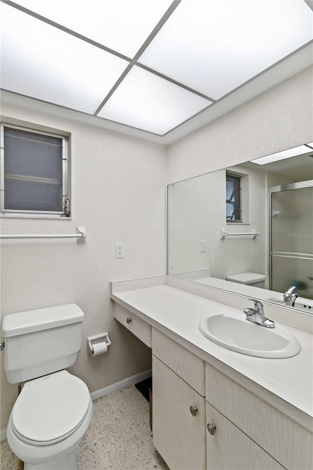 bathroom with vanity, toilet, and a shower with shower door