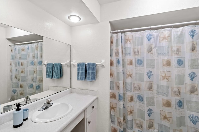 bathroom with walk in shower and vanity