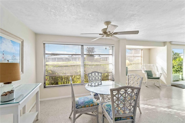 dining area featuring ceiling fan and a textured ceiling