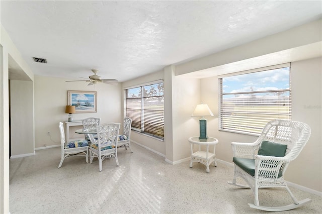 dining area featuring ceiling fan and a textured ceiling