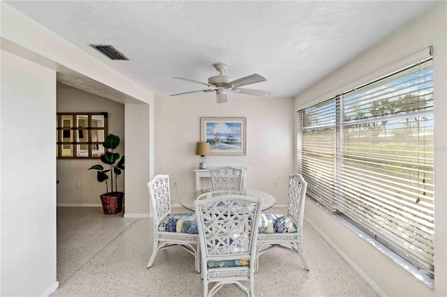 dining room with ceiling fan and a textured ceiling