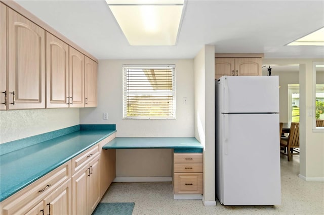 kitchen featuring light brown cabinets and white fridge