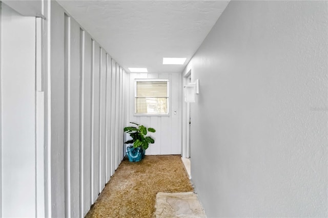 hallway featuring a skylight and a textured ceiling