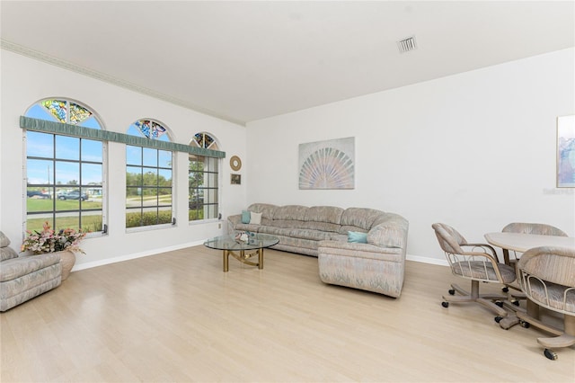living room featuring visible vents, baseboards, and wood finished floors