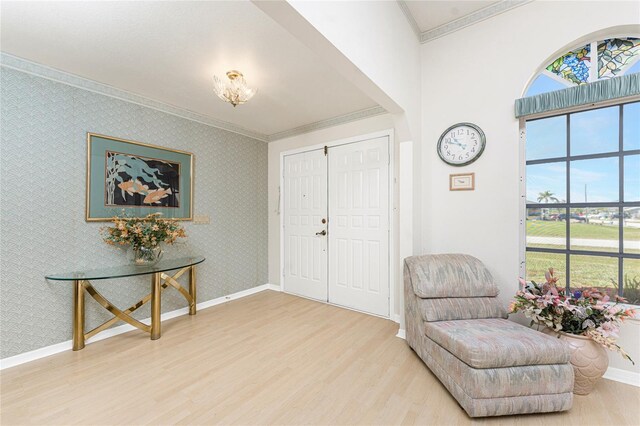 foyer featuring baseboards, ornamental molding, and wood finished floors