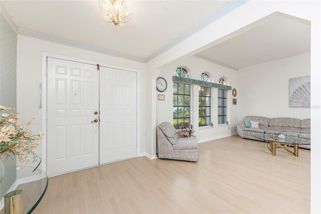 entryway with wood finished floors, an inviting chandelier, baseboards, and ornamental molding