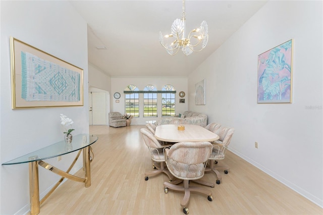 dining space featuring wood finished floors, a notable chandelier, and baseboards