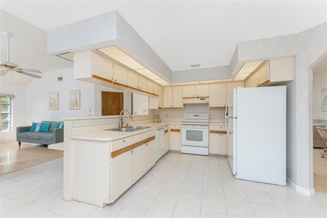 kitchen with a sink, open floor plan, white appliances, a peninsula, and under cabinet range hood