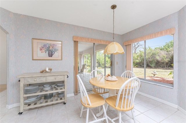 dining space with light tile patterned flooring, baseboards, and a wealth of natural light