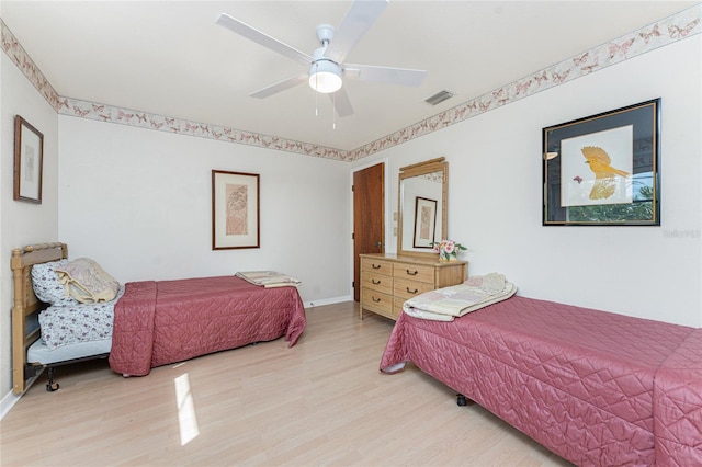bedroom with visible vents, baseboards, light wood finished floors, and ceiling fan