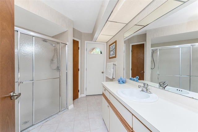 bathroom featuring tile patterned floors, a stall shower, baseboards, and vanity