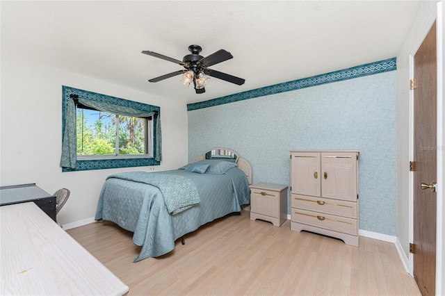 bedroom featuring light wood-type flooring, wallpapered walls, ceiling fan, and baseboards