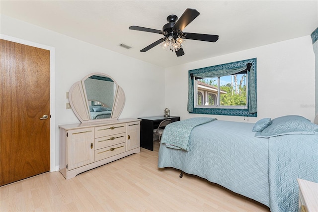 bedroom with light wood-style flooring, ceiling fan, and visible vents