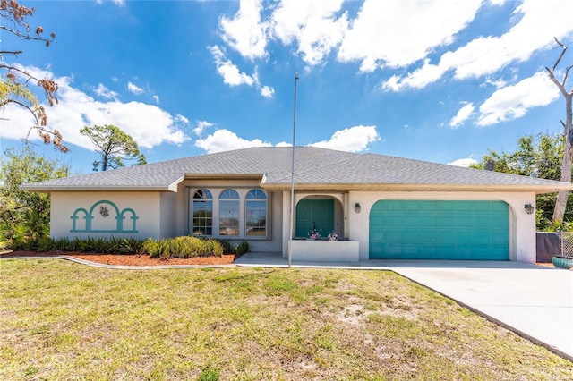 view of front of home with a front yard, driveway, a garage, and stucco siding