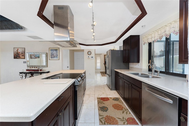 kitchen with appliances with stainless steel finishes, a tray ceiling, light countertops, and a sink