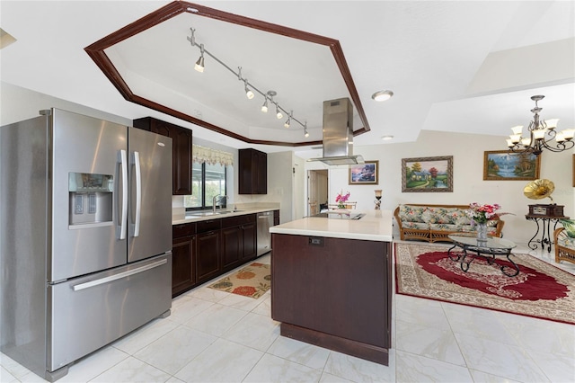 kitchen with decorative light fixtures, island exhaust hood, light countertops, appliances with stainless steel finishes, and a sink