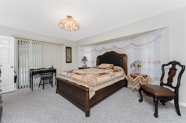 bedroom featuring light colored carpet and a notable chandelier