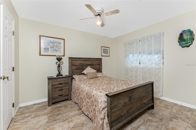 bedroom with a ceiling fan and baseboards