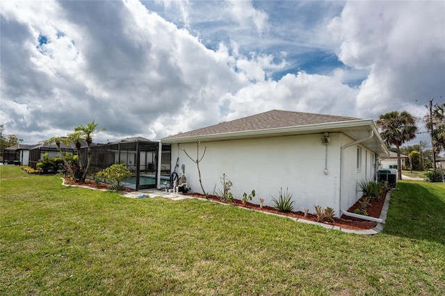 back of house featuring glass enclosure, a lawn, a swimming pool, and stucco siding