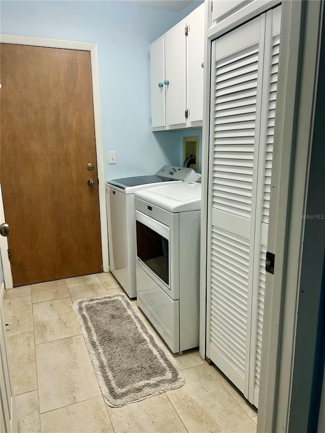 washroom featuring cabinet space and washing machine and clothes dryer