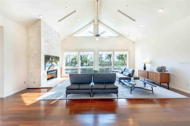 living room with high vaulted ceiling, beamed ceiling, a large fireplace, hardwood / wood-style flooring, and ceiling fan