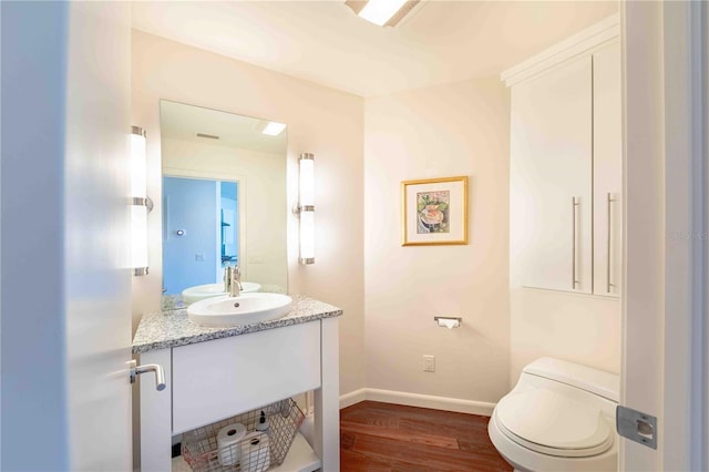 bathroom featuring vanity, toilet, and hardwood / wood-style floors