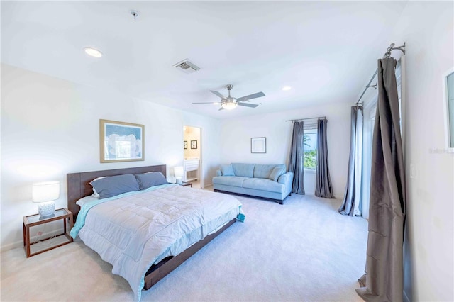 bedroom with connected bathroom, light carpet, and ceiling fan