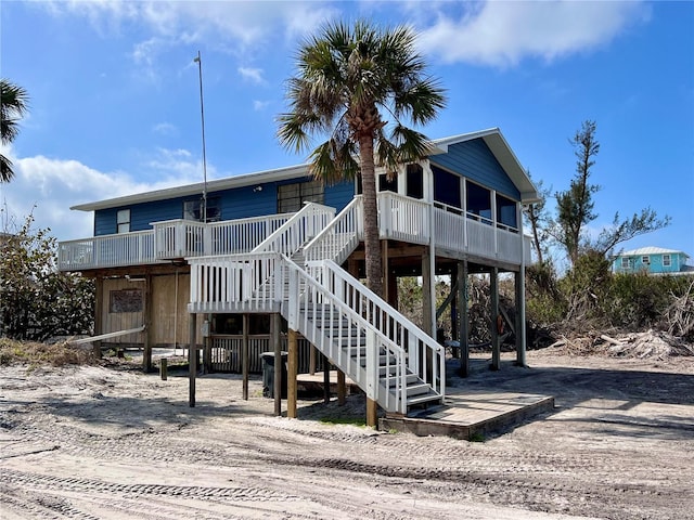 view of front of house featuring a carport, stairway, and driveway