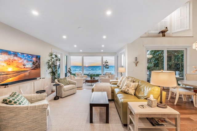 living room featuring a water view and light hardwood / wood-style flooring