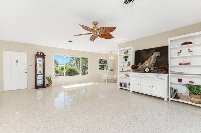 living room featuring light speckled floor, visible vents, and ceiling fan