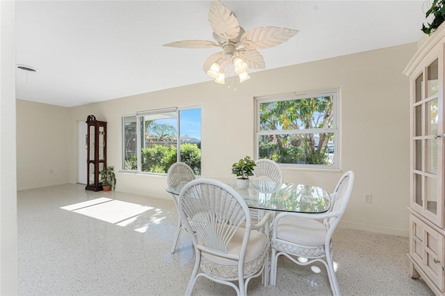 dining room featuring light speckled floor, ceiling fan, and baseboards