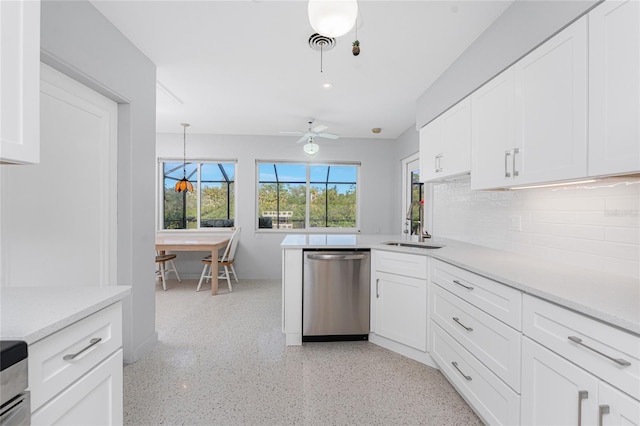 kitchen featuring light countertops, stainless steel dishwasher, and white cabinets