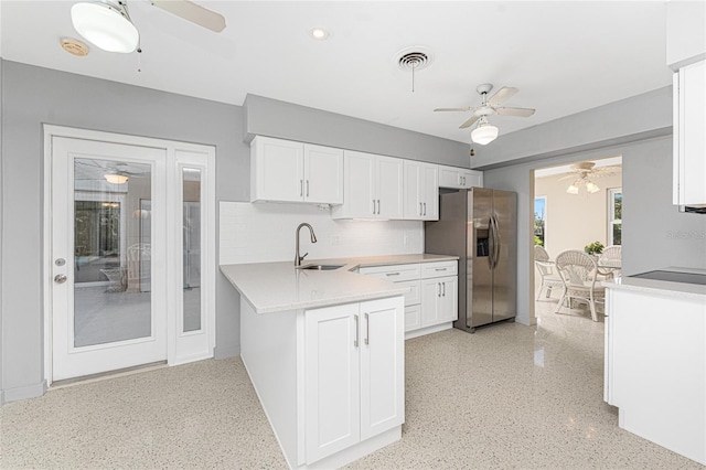 kitchen with a sink, visible vents, white cabinetry, light countertops, and stainless steel fridge with ice dispenser